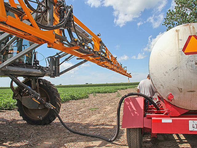 A sprayer is loaded with herbicides in central Illinois. Farmers and retailers are running into tight supplies and shipping delays for certain ag chemicals, particularly herbicides, this spring. (DTN photo by Pam Smith)