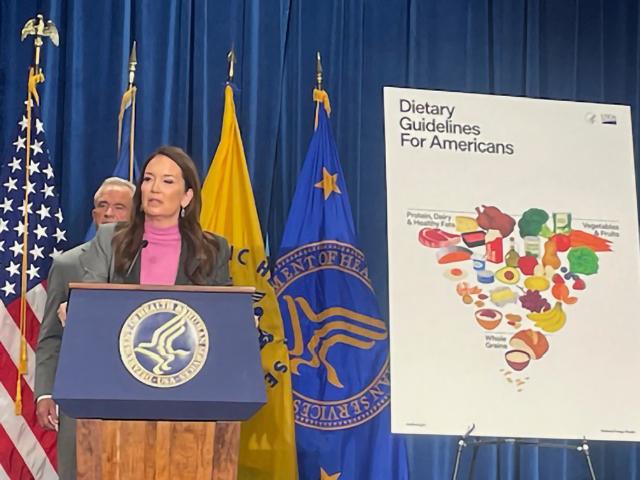 Agriculture Secretary Brooke Rollins talks about how USDA will implement the new Dietary Guidelines for Americans with Health and Human Services Secretary Robert F. Kennedy Jr. looking over her shoulder. (Photo by Jerry Hagstrom) 