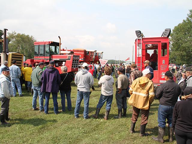 Farmers look over used equipment at a farm auction. Plans by the White House to eliminate stepped-up were discussed by senators on Tuesday who spoke to members of the North American Agricultural Journalists (NAAJ). The plan could generate $113 billion in taxes over ten years because it would drive wealthier people to sell assets rather than pass them on to heirs. (DTN file photo by Elaine Shein)
