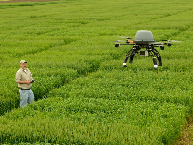 Rory Paul of Volt Aerial Robotics flies a rotary-winged UAV over a wheat field to demonstrate its crop scouting abilities. (DTN/The Progressive Farmer photo by Jim Patrico)