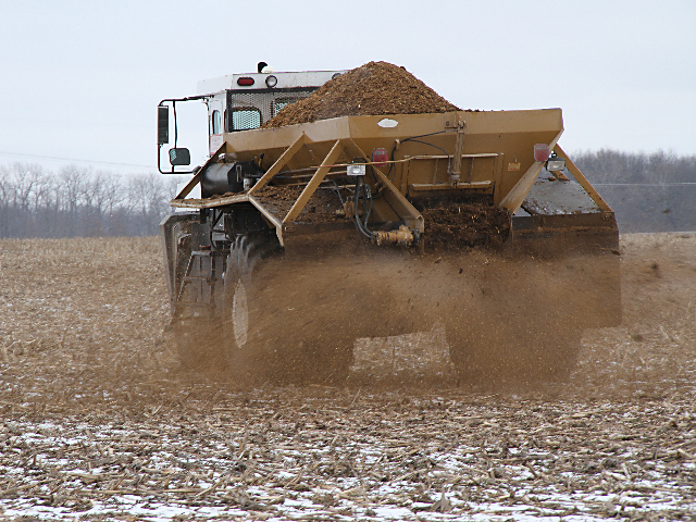 A manure spreader passes over a field. (DTN file photo)