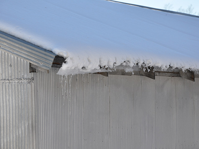 Snow that looks picturesque from afar, looks different when trying to clear a roof. (DTN photo by Jim Patrico)