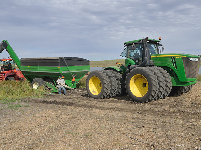 A grain cart stuck in the mud is rescued by a 4WD tractor and strategic planning. (DTN/The Progressive Farmer photo by Jim Patrico)