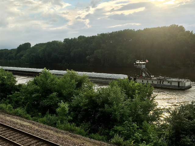 A tow pushes barges downriver toward St. Paul, Minnesota, where water levels have risen once again. (Photo by Ann Kennedy, Austin, Texas)