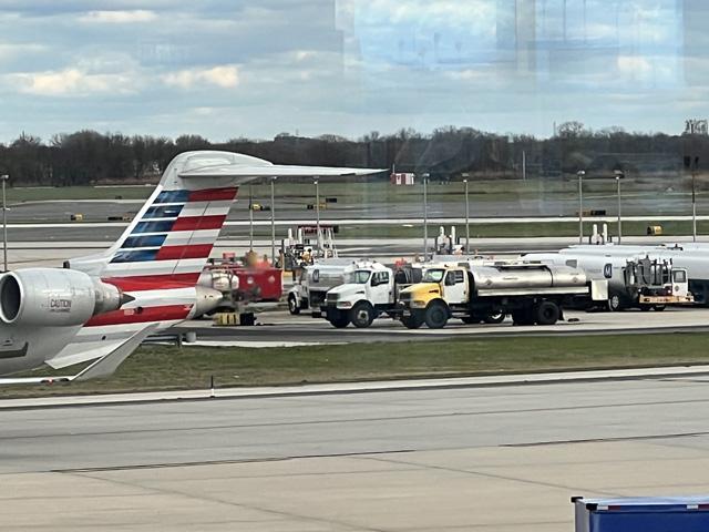 Jet fuel trucks lined up in the middle of the tarmac as a commercial jet goes by. As Sustainable Aviation Fuel production begins to rise, a group of lawmakers wants to the U.S. Energy Information Administration to publish more weekly and monthly data. (DTN file photo by Chris Clayton) 