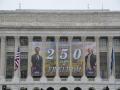 USDA's headquarters building with a banner celebrating the country's 250th anniversary. To boost Defense spending, the White House proposes an array of cuts across the federal budget, including a $4.9 billion cut to USDA programs. (DTN photo by Chris Clayton) 