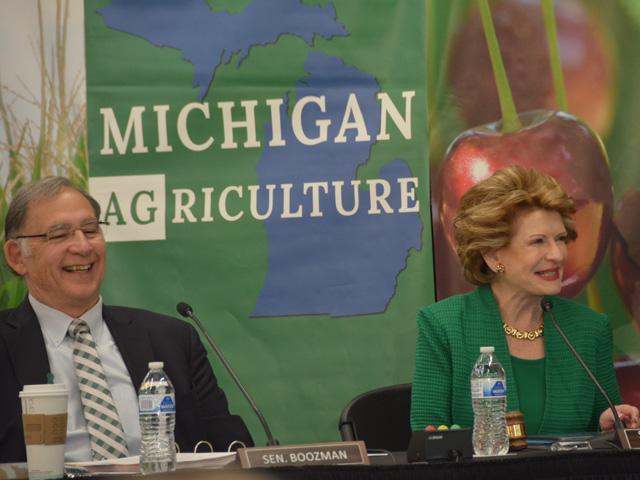 Sen. Debbie Stabenow, D-Mich., chairwoman of the Senate Agriculture Committee, shares a laugh with Sen. John Boozman, R-Ark., ranking member of the committee, during a field hearing last spring in Michigan. Stabenow announced Thursday she will not seek another Senate term. (DTN file photo by Chris Clayton) 
