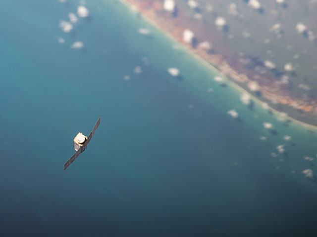 A tiny Dove satellite floats over the Earth after being deployed from the International Space Station. (Photo courtesy of NASA)