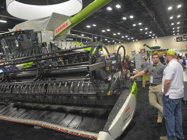 A CLAAS representative talks to a farmer about the capabilities of its new Lexion 7500 combine at Commodity Classic in San Antonio last month. (DTN photo by Matthew Wilde)