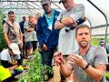 Cory Bryk, of New Life Farm, explains the finer points of trimming tomato plants. (DTN/Progressive Farmer photo by Des Keller)
