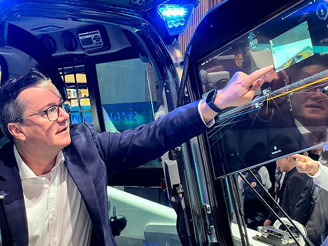 Joel Honeyman, VP of Global Innovation for Bobcat, demonstrates imagery and task planning displayed on the glass surface of the cab door of Bobcat&#039;s new battery-powered S7X skid-steer loader. (Dan Miller)