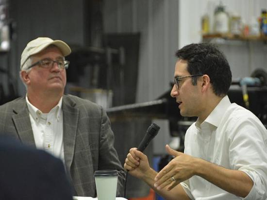 Former Federal Trade Commissioner Alvaro Bedoya talks about market power and agriculture with Iowa Farmers Union President Aaron Lehman at a meeting on Saturday at a farm just outside of Ankeny, Iowa. Bedoya was fired by President Donald Trump in March, though he is among a group of commission and board members at various agencies suing to overturn those terminations. (DTN photo by Chris Clayton)