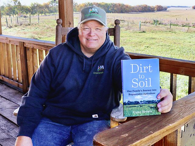 Gabe Brown poses with his book "Dirt to Soil." (Des Keller)