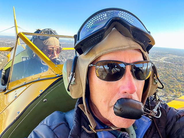Gaining a higher perspective, Gregg Hillyer ponders farm life far below from the front of a World War II era biplane, with Douglas Watanabe in the rear seat piloting the plane. (Gregg Hillyer)

