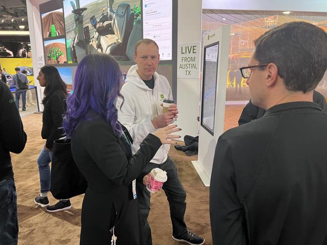 Jahmy Hindman leads a John Deere contingent to CES 2024 to show the sustainable benefits of agricultural technology. In the background, Deere is demonstrating its autonomous tractor operating on its test farm outside Austin, Texas. Show attendees can remotely start and stop the tractor from the floor of the CES. (DTN photo by Dan Miller)