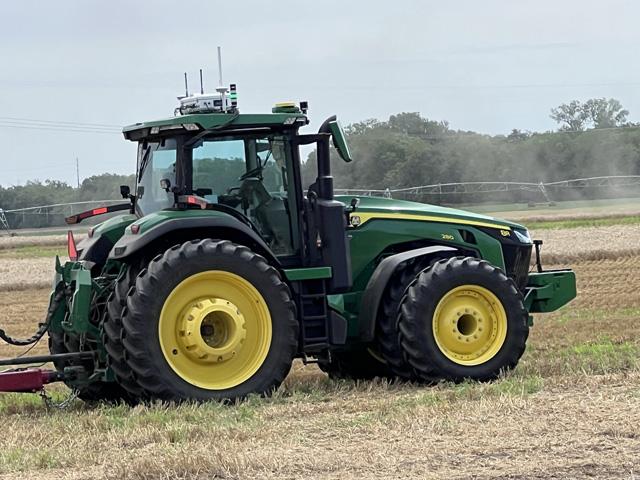 Initially, AGCO is mounting its autonomous grain cart retrofit to one of its Fendt tractor models and to Deere&#039;s 8R tractor. See here the white-colored retrofit mounted to the top of a Deere 8R tractor. Autonomous retrofits for additional tractor brands will be soon coming. (DTN photo by Dan Miller)