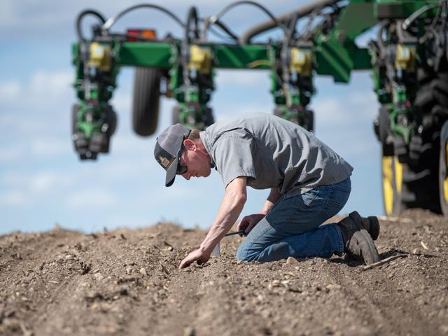 Tyler Rath of Belgrade, Minnesota, checks seeding depth on corn being planted in an organic production system. Rath is one of the farmers providing insights about the 2026 crop season as part of DTN's View From the Cab series. (DTN photo by Joel Reichenberger)