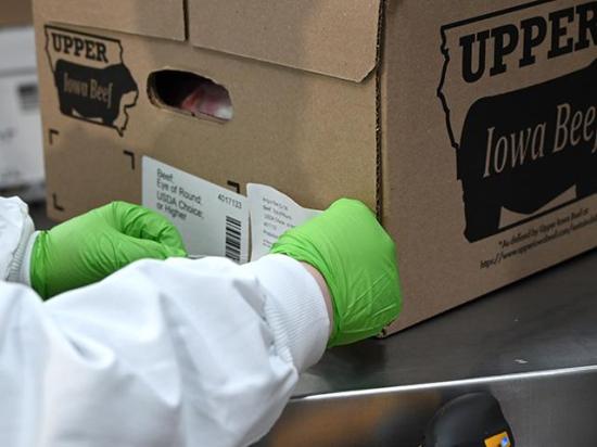A worker at Upper Iowa Beef puts a label on a beef box, showing what the container holds. (DTN/Progressive Farmer photo by Jennifer Carrico)