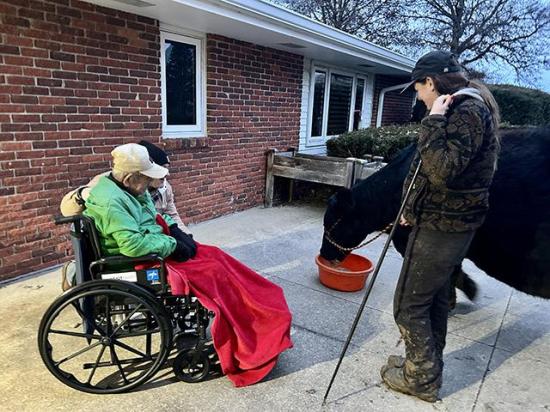 Kassidy Bremer, right, shares her cow, Jolene, with Community Care Center residents and retired farmers in Stuart, Iowa. (DTN/Progressive Farmer photo by Jennifer Carrico)