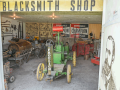 The blacksmith shop at the Froelich Tractor and 1890s Village Museum in Froelich, Iowa, houses a replica of the first gasoline-powered tractor, which was invented by John Froelich (pictured on the door on the right). The shop also contains hundreds of other ag and period artifacts. (DTN photo by Matthew Wilde)