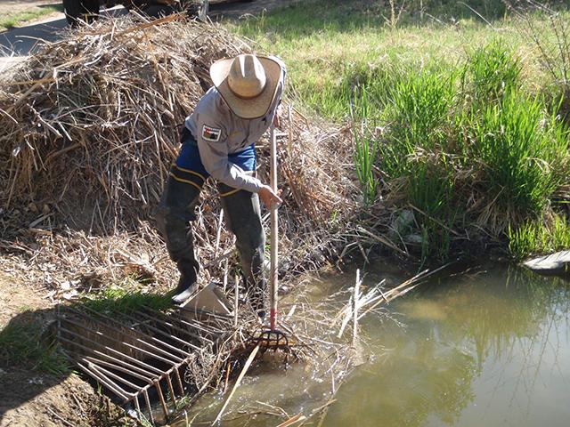 A USDA employee is moving debris from a flood-control culvert. USDA on Monday rolled out a new Working Lands Climate Corps, part of a broader overall effort in the Biden administration to develop younger workers who can focus on climate mitigation and adaptation strategies. (Photo courtesy of USDA) 