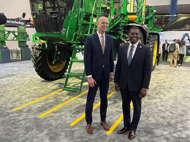 EPA Administrator Michael Regan, right, and Rod Snyder, EPA's agricultural advisor, pose in front of a John Deere sprayer on the expo floor of Commodity Classic. Regan created a new Agriculture and Rural Affairs office that Snyder will lead. (DTN photo by Jerry Hagstrom) 