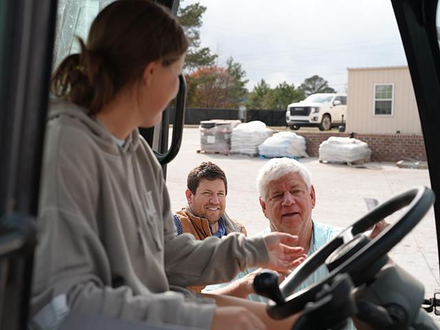 Fertilizer loadout operator Danielle Morgan receives instructions from Mike Carroll, owner of Meherrin Fertilizer in Four Oaks, North Carolina, while sales manager Andrew Carroll looks on. (Photo courtesy of Meherrin Fertilizer)
