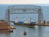 The first ocean vessel of the season, saltie Motor Vessel Ocean7 Ranger, arrived under the Duluth, Minnesota, lift bridge on April 8, accompanied by tugs North Carolina and Missouri. (Photo courtesy of Schauer Photo Images)