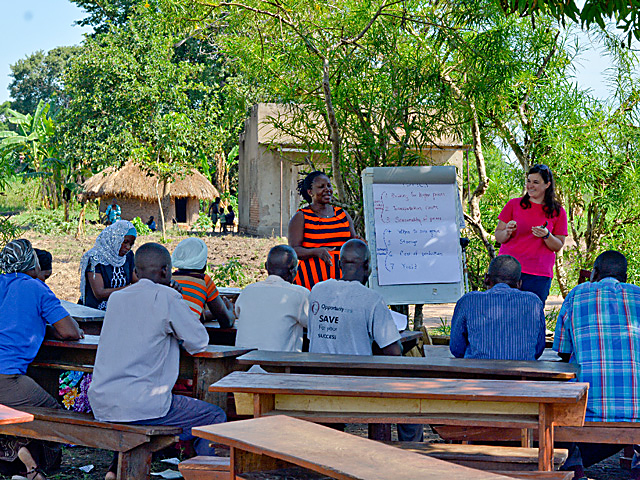 With Doreen Namuwaya translating, DTN Contributing Analyst Elaine Kub discusses grain marketing with the men and women of Nolla Farmers Group near Nkaiza, Bugiri Region, Uganda. (Photo courtesy of Elaine Kub)