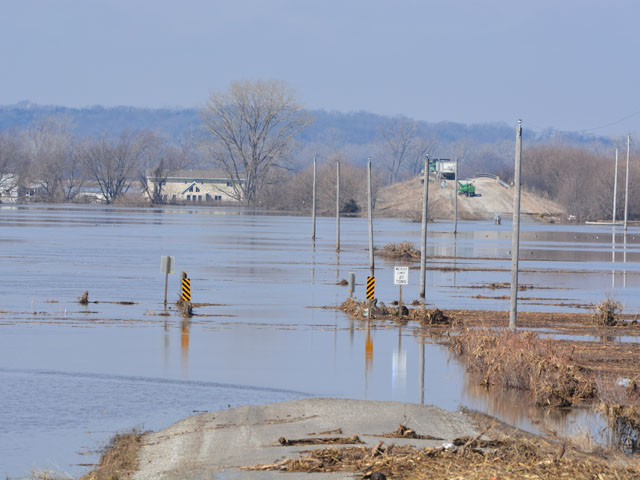 A road is washed out and a bridge that normally goes over Interstate 29 is now a storage spot for equipment above the water. At least 40 miles of Interstate 29 in Iowa are underwater. (DTN photo by Chris Clayton)