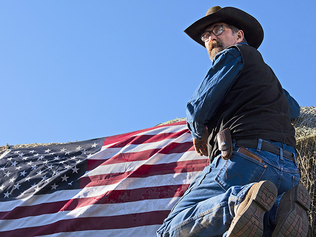 Raymond Winkler attaches an American flag to his hay load to help identify him as an Ashes to Ashes convoy driver. (Progressive Farmer photo by Joel Reichenberger)