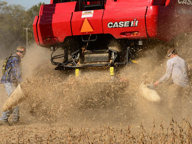 University of Missouri graduate students Del Knerr (left) and Brian Dintelmann collect samples of weed seeds and soybean residue that was crushed by the Seed Terminator. (DTN photo by Gregg Hillyer)
