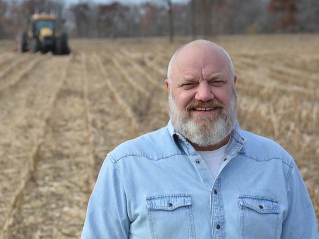 Craig Rupp, founder and CEO of Sabanto, announced several agriculture-based companies invested $17 million in his company to help it grow. This includes outfitting tractors, like the one behind Rupp, that farmers own with autonomous technology. (DTN photo by Matthew Wilde)