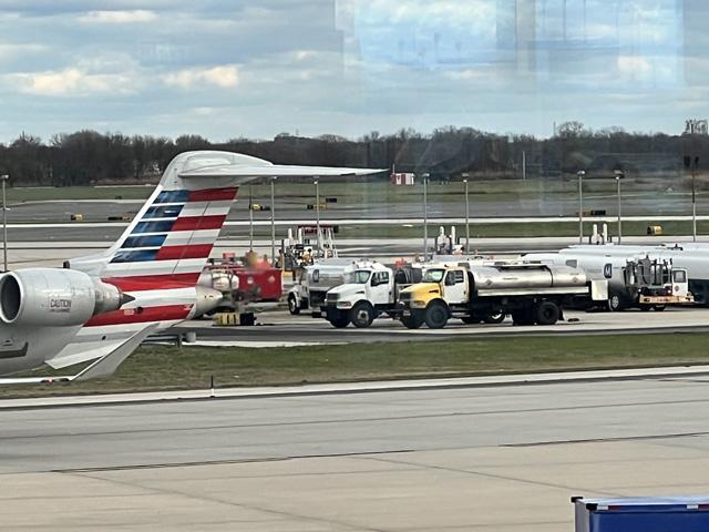 Jet fuel trucks lined up in the middle of the tarmac as a commercial jet goes by. Treasury Department officials on Tuesday released the rules for the first round of sustainable aviation fuel tax credits. To qualify, biofuel producers will have to show they can have at least 50% lower emissions than petroleum-based jet fuel. (DTN photo by Chris Clayton)