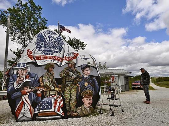 Ray "Bubba" Sorensen stands back to look at the south side of the Freedom Rock which he was completing the week before Memorial Day. (DTN/Progressive Farmer photo by Jennifer Carrico)