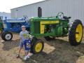 Brothers Kyle (8 years old) and Burke Quinn (3) stand next to their late great-grandpa J.B. Quinn&#039;s 1957 John Deere 620 tractor in 2012. Ten years later, Kyle (17) is now a junior in high school, while Burke (12) is a seventh grader. (DTN photo by Russ Quinn)