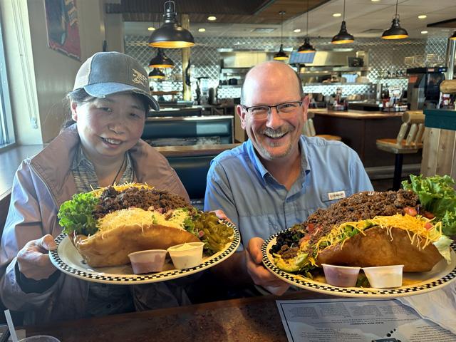 Cindy Li with Bimbo Bakeries USA and DTN Crops Editor Jason Jenkins attempted to tackle the "Wow! Taco Salad" for lunch at the Black Bear Diner in Garden City, Kansas, during Day 2 of the 2025 Hard Winter Wheat Tour. (Photo courtesy of Tyllor Ledford)