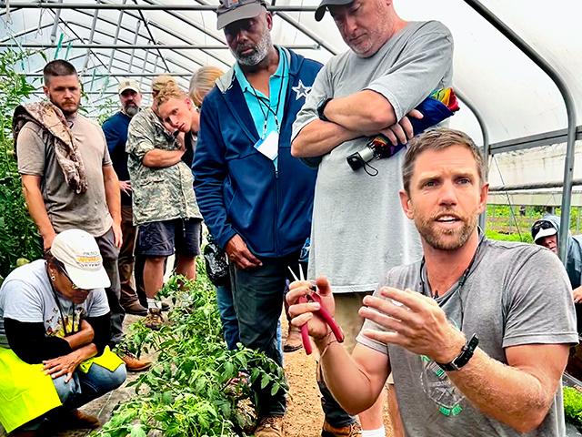 Cory Bryk, of New Life Farm, explains the finer points of trimming tomato plants. (Des Keller)