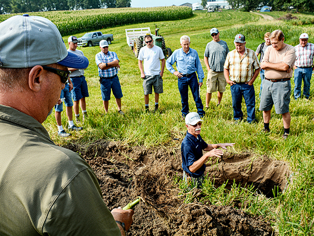Mike Petersen (in the soil pit), Orthman Manufacturing agronomist, uses soil pits to demonstrate to farmers the importance of good soil health and root development. (Matthew Wilde)