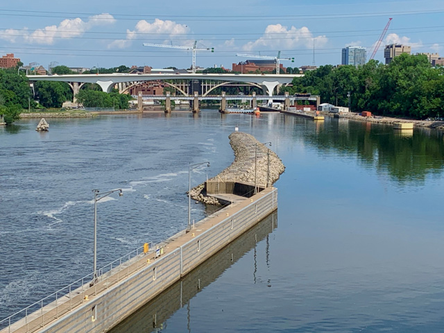 The new I-35W bridge can be seen downriver from St. Anthony Falls after the original bridge collapsed into the Mississippi River Aug. 1, 2007, killing 13 people and injuring 145. In 2005, the bridge was rated as structurally deficient and in possible need of replacement, according to the U.S. Department of Transportation National Bridge Inventory database. An inspection carried out on June 15, 2006, found problems of cracking and fatigue. On the right is the pool to the now-closed St. Anthony Lock and Dam. The Water Resources Reform and Development Act of 2014 prompted that closing, and while no reason was specified for the lock closure, it was surmised as an attempt to stop the spread of Asian carp upriver from the Falls. (DTN photo by Mary Kennedy)