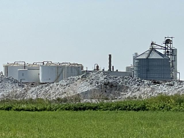 A pile of old contaminated distilled grain at the defunct AltEn ethanol plant near Mead, Nebraska. There is as much as 115,000 tons of old distilled grain piled on the site that came from concentrated volumes of treated seed. The group in charge of the cleanup is now testing a strategy to move as much as 24,000 tons to a landfill. (DTN file photo)