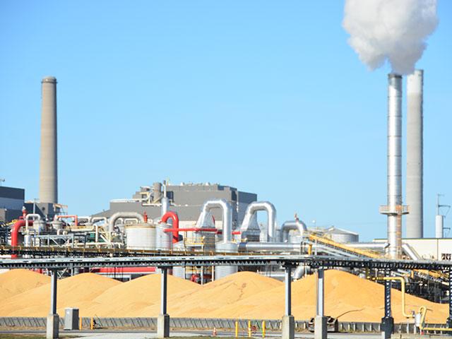 An ethanol plant in southwest Iowa with corn stacked outside after harvest. As corn growers worry about demand loss from tighter emission standards on cars and pickups, researchers point to worries about corn acreage increasing due to a drive to use biofuels for airlines. (DTN file photo)