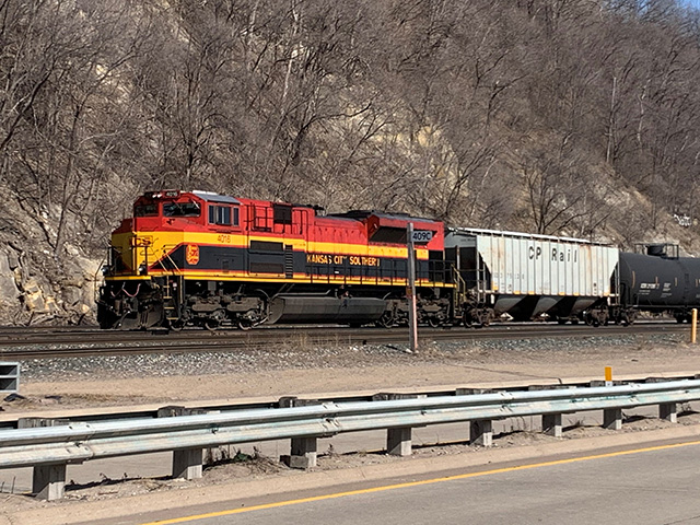 A Kansas City Southern engine behind a buffer car at the end of a tank car train pulled by the Canadian Pacific along the Mississippi River bluffs in downtown St. Paul, Minnesota, late March. (DTN photo by Mary Kennedy)