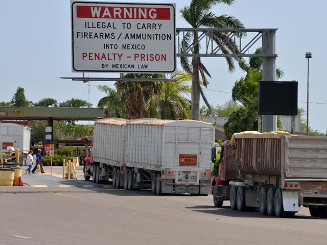 Trucks carrying corn move across the Progreso International Bridge in Texas into Mexico in August 2017. The Progreso bridge saw lines back up more than 2 miles earlier this week with semi-trucks after Mexican drivers protested at another border crossing about a half hour away. (DTN file photo) 