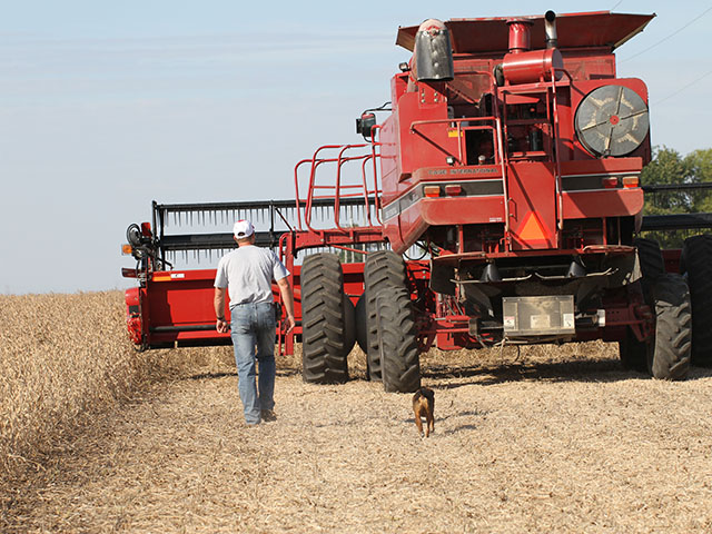 Illinois farmer Aaron Rients and his faithful dog, Remi, head out to harvest the final soybean field of the 2015 season. USDA is predicting record national soybean yields this year. (DTN photo by Pamela Smith)