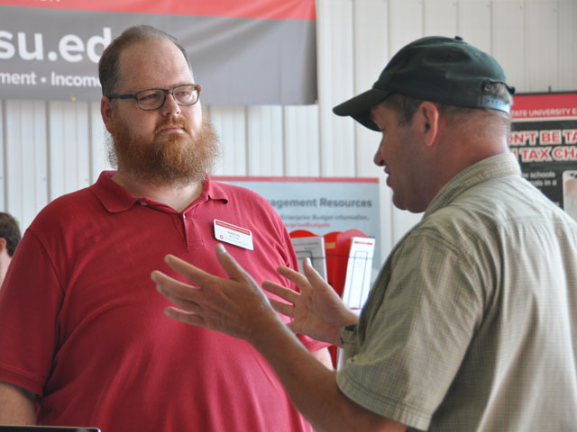 Ohio State climate researcher Aaron Wilson talks with an attendee at the Farm Science Review, where he is highlighting the need for local solutions to climate change. (DTN photo by Emily Unglesbee)