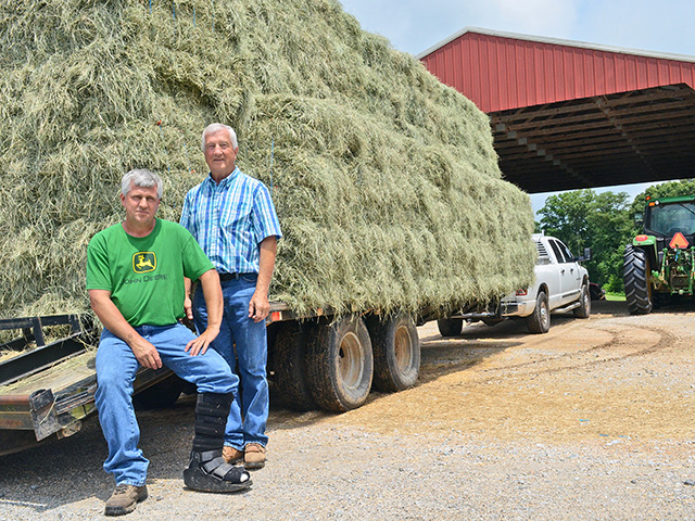By the time hay seasons ends, Scott Woolfolk (left) and dad, Johnny, will have handled more than 25,000 small, 50-pound hay bales, selling most into the area&#039;s horse market. (Progressive Farmer photo by Victoria G. Myers)