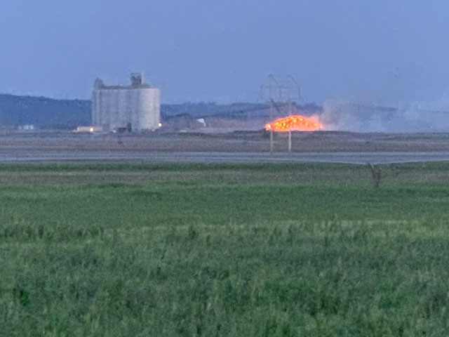 An outdoor pile of soybeans that combusted during the summer heat earlier this month off Interstate 29 in northwest Missouri appeared to be covered in flames Friday. (Photo courtesy of Richard Oswald) 