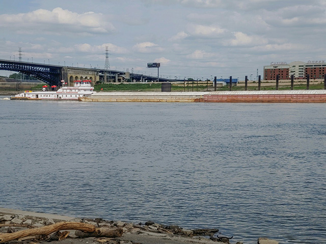 A barge moves through St. Louis, Missouri, on the Mississippi River in fall 2020, with noticeable shoreline exposure visible due to low water conditions. (Photo by CAPT Daniel Halvorson, U.S. Army)