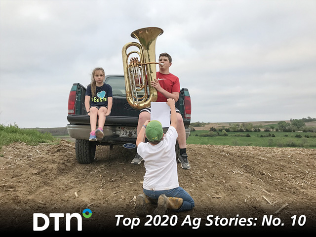 Kyle Quinn, 16, played his tuba from a high spot on the Quinn farm in order to get enough mobile phone signal to send his performance to his band teacher during the spring of 2020. Brother Burke, 11, held the music as sister Ella, 9, listened. (DTN photo by Russ Quinn)